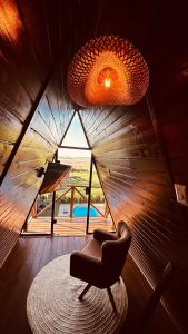 a living room with a chair and a large window at Cabanas Farol in Pântano Grande