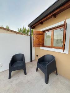 due sedie nere sedute su un patio accanto a un edificio di Complejo Malagi a Barrio Félix U Camet