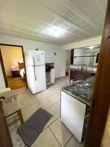 Una cocina con un refrigerador blanco y una estufa. en Recanto do majo, en Petrópolis 2 fotos más