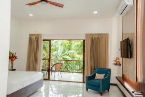 a bedroom with a bed and a chair and a balcony at Hotel Sanctuarium in Fortuna