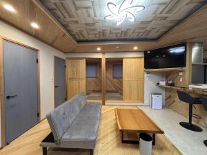 a living room with a couch and a table at ハレとケ in Aso