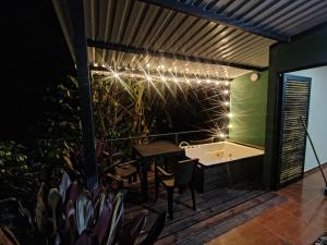 a deck with a table and chairs and a bathtub at Cabañas el guadual in La Vega