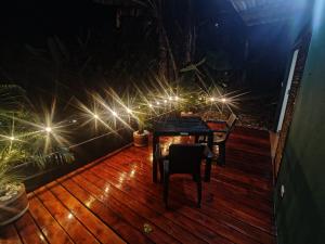 a table and chairs on a deck with lights at Cabañas el guadual in La Vega +8 photos