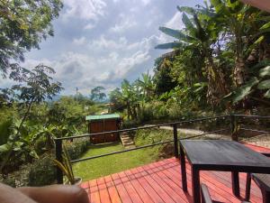 a balcony with a table and a view of a garden at Cabañas el guadual in La Vega