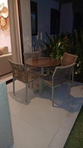 ein Holztisch und vier Stühle um einen Holztisch in der Unterkunft Villa sol e mar, seu refúgio em Muro Alto in Ipojuca + 46 Fotos