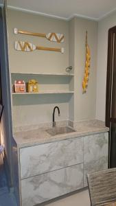eine Küchentheke mit Spüle und Regalen in der Unterkunft Villa sol e mar, seu refúgio em Muro Alto in Ipojuca