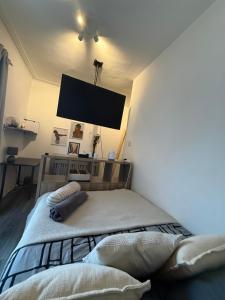 Un dormitorio con una cama con un televisor en la pared. en Home From Home, en Liverpool