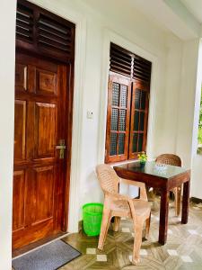 a room with a table and a wooden door at Lionka Guesthouse in Mirissa