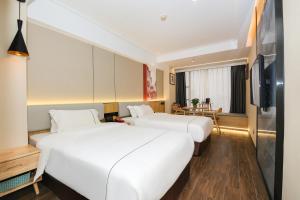 Una habitación de hotel con dos camas y un televisor. en Chenlong Cafe Hotel, en Guangzhou