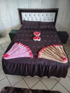 a bed with a black comforter and pillows on it at Beleza de Angra Apartamento Aconchegante in Angra dos Reis