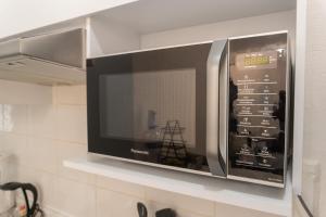 eine Mikrowelle auf einem Regal in einer Küche in der Unterkunft Departamento Acapulco Diamante in Acapulco
