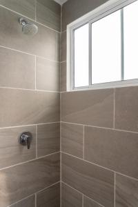 ein Bad mit einer Dusche und einem Fenster in der Unterkunft Departamento Acapulco Diamante in Acapulco