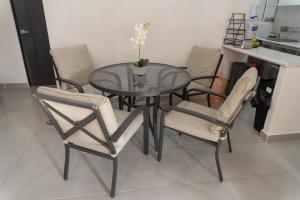 einen Esstisch und Stühle mit einem Glastisch in der Unterkunft Departamento Acapulco Diamante in Acapulco