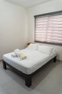 ein großes Bett in einem Zimmer mit Fenster in der Unterkunft Departamento Acapulco Diamante in Acapulco