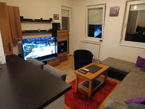 a living room with a couch and a tv and a table at Apartman MM , Banja Luka, Wi-Fi free,parking free in Banja Luka