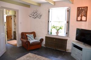 a living room with a chair and a television at Sea Haze Charlestown in St Austell