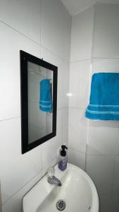 y baño con lavabo, espejo y toallas azules. en Hermosa Vista al Mar en Rodadero, en Gaira 29 fotos más