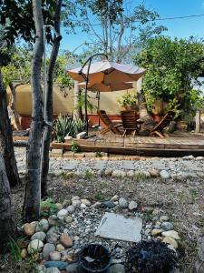 a patio with a table and an umbrella at Punta Surf Cabañas & Glamping in Brisas de Zicatela