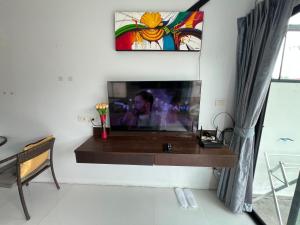 a living room with a tv on a wall at Nern khao Guesthouse in Kamala Beach