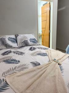 a bed with black and white sheets and pillows at Eds pousada in Juazeiro do Norte