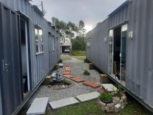 una hilera de contenedores de transporte grises estacionados uno al lado del otro en Canela Container, en Canela