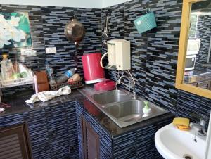 Una encimera de cocina con un fregadero y un fregadero. en บ้านเพื่อนโฮมสเตย์, en Ban Muang (1)