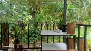a balcony with a table and a view of a forest at Chalee Guest House in Ban Khlong Mat