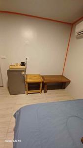 a room with a bed and a table and a desk at Chalee Guest House in Ban Khlong Mat