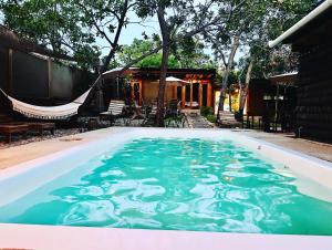 a swimming pool with blue water in front of a house at Punta Surf Cabañas & Glamping in Brisas de Zicatela
