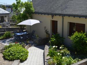 a small house with a table and an umbrella at Gîte Vouvray sur un Domaine Viticole, Proche Châteaux de la Loire - FR-1-381-167 in Vouvray