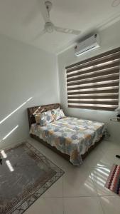 - une chambre avec un lit et une fenêtre avec des stores dans l'établissement Zahra Homestay, à Kota Bharu 4 autres photos