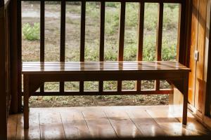 a wooden bench sitting in front of a window at The Good House in Gili Air +2 photos