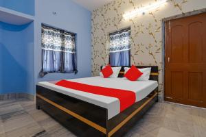um quarto com uma cama com paredes azuis e almofadas vermelhas em Hotel O Buddha Paradise em Patna