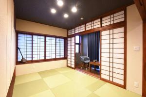 Cette chambre dispose de fenêtres, d'une chaise et d'un bureau. dans l'établissement ORENCHii, à Yomitan