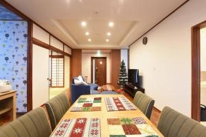 a room with a table with a christmas quilt on it at ORENCHii in Yomitan +9 photos