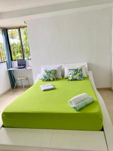 a large green bed in a room with a table at Apartamento Boutique Cartagena Plaza de Toros in Cartagena de Indias