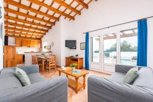 a living room with two couches and a table at Villa Ingrid Porter by Villa Plus in Cala en Porter