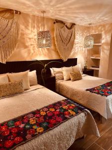 een slaapkamer met twee bedden met bloemen erop bij Villa Lol Tun Breakfast and Beach Club Included in Isla Mujeres