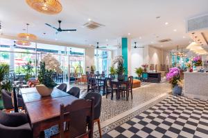 a restaurant with tables and chairs and a lobby at Sujet Beach Hotel and Apartment Danang by Haviland in Da Nang