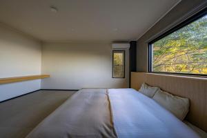 a large bed in a room with a window at Amao Villa 自然郷 in Atami