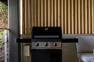 a stove with a microwave on top of it next to a couch at Amao Villa 自然郷 in Atami