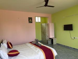 a bedroom with a bed and a ceiling fan at S N Greens in Chik Bānavar