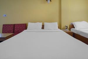 甘托克Collection O SHANTI PRIYA的带两张床和一张沙发的卧室