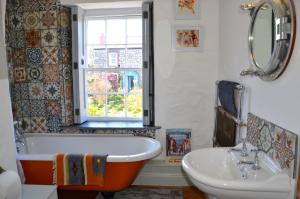 a bathroom with a tub and a sink and a window at Sea Haze Charlestown in St Austell