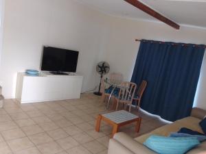 a living room with a tv and a table and chairs at Beachcomber in Burrum Heads