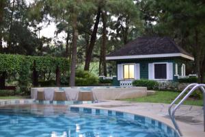 a swimming pool with chairs and a house in the background at Alpine Haven at Alpine Villas by Crosswinds Tagaytay & Free Parking in Sampong