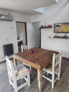 a wooden dining room table with chairs and a television at Benito Soria 137 in Santa Rosa de Calamuchita