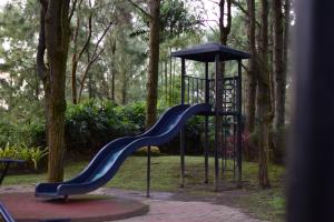 a playground with a blue slide and an umbrella at Alpine Haven at Alpine Villas by Crosswinds Tagaytay & Free Parking in Sampong
