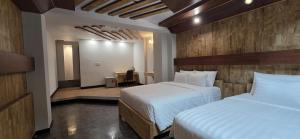 En eller flere senge i et værelse på Hola Hotel