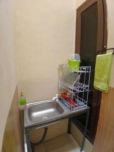 eine Küchenspüle mit einem Geschirrregal daneben in der Unterkunft Homestay Nyaman di Pusat Kota in Blimbing